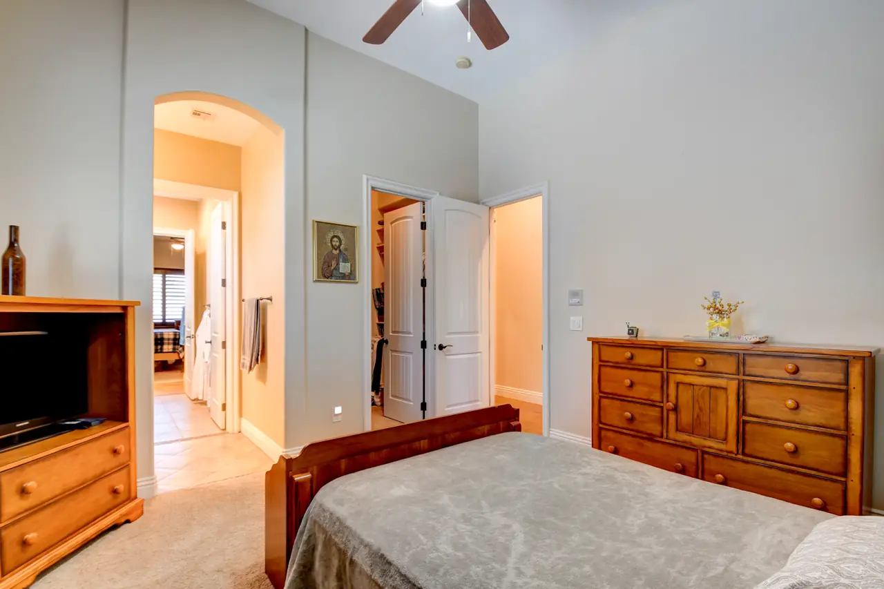 Bedroom with an arched doorway and access to its bath and closet