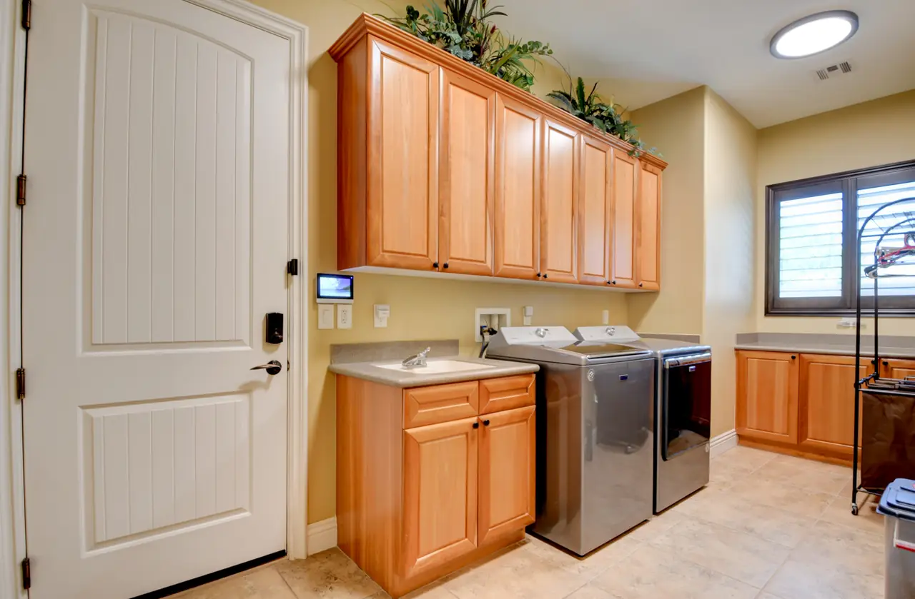 Laundry room with wood cabinets, a sink, washer and dryer