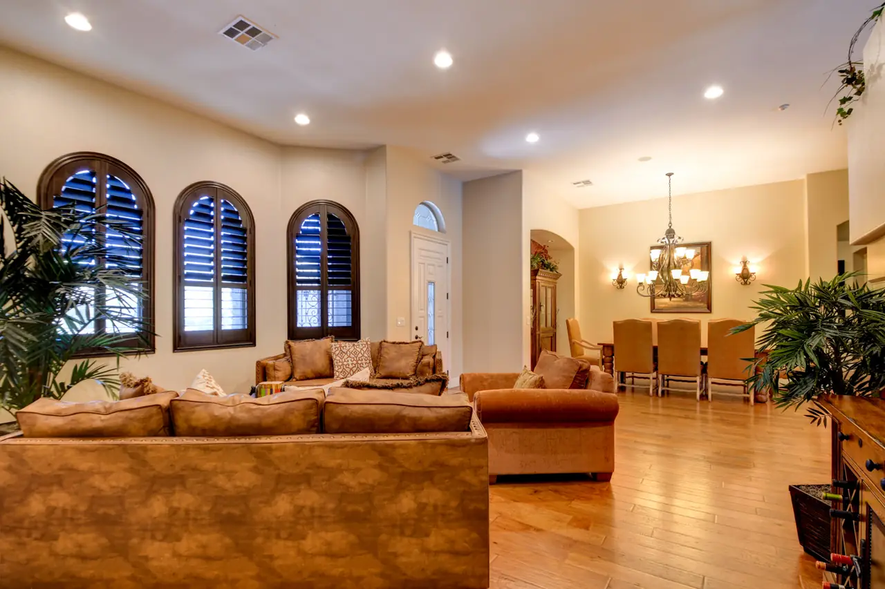 Living room with arched plantation-shuttered windows and the dining room beyond